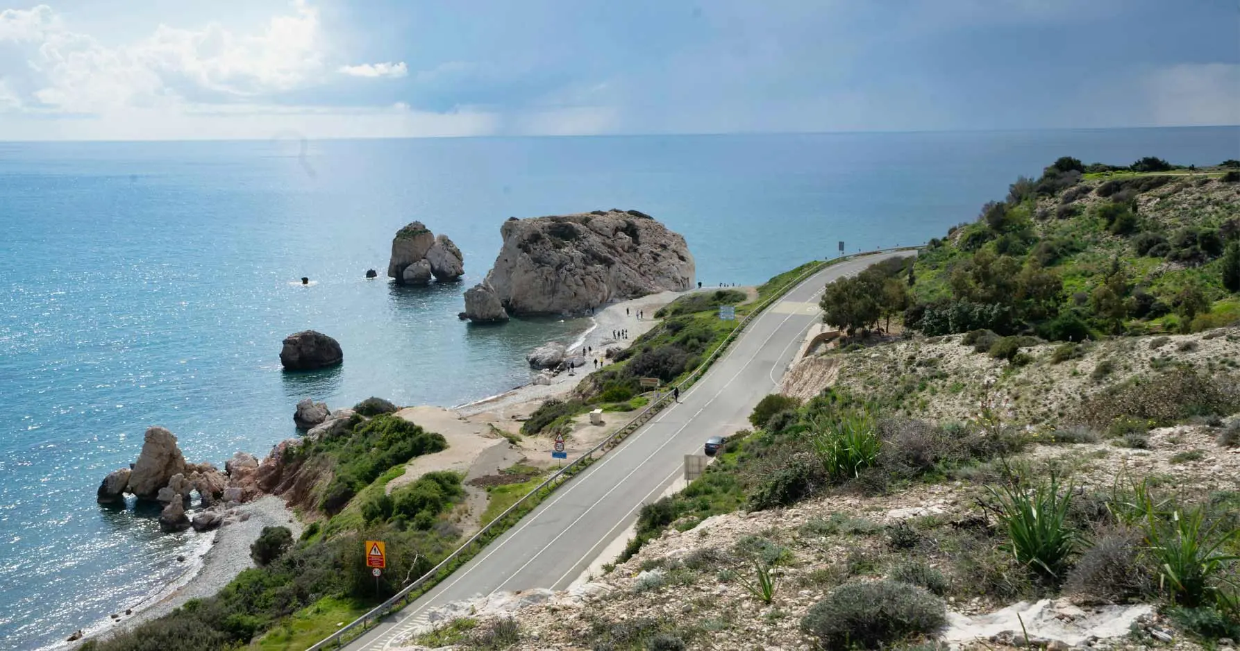 Expansive view of the sea, winding road, and rocks in Cyprus,