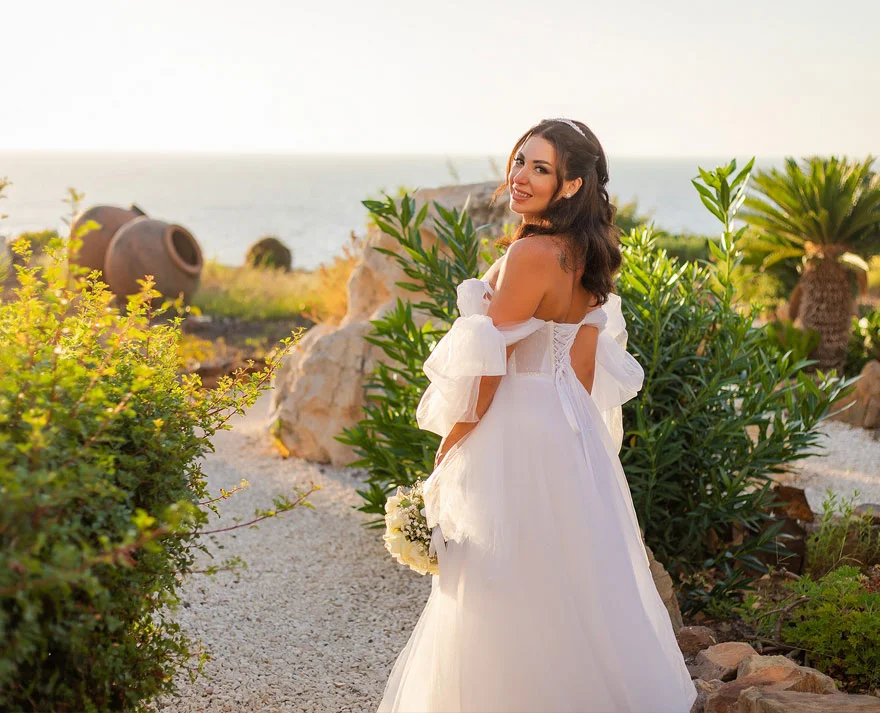 Bride standing in lush green nature, in Cyprus