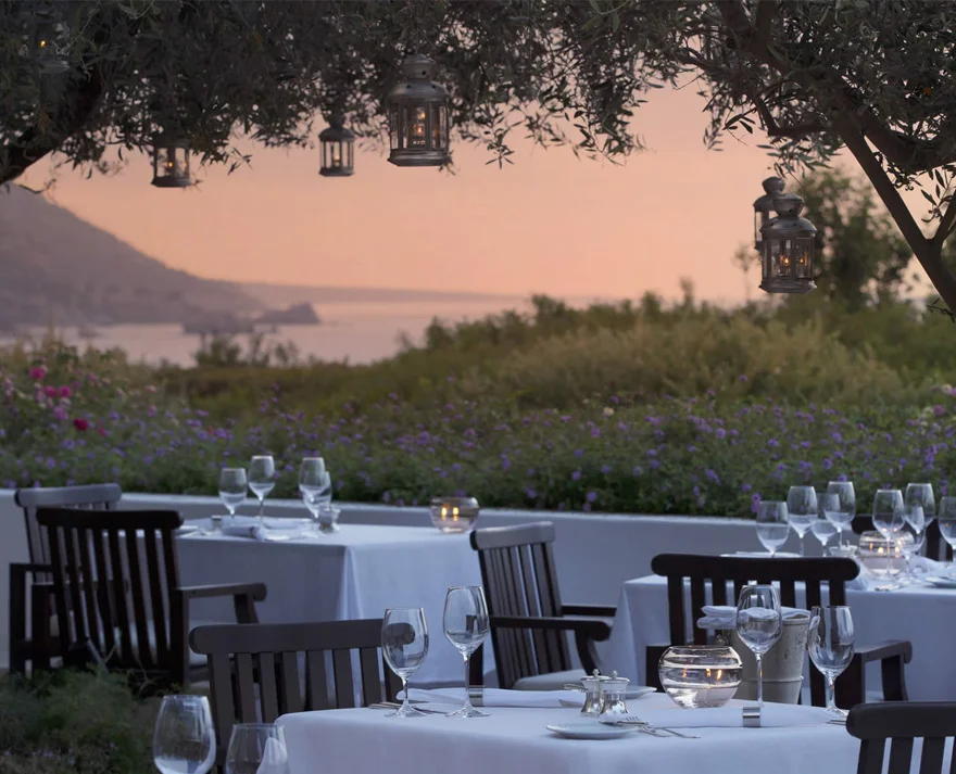 Evening ambiance, tables under trees, overlooking the sea